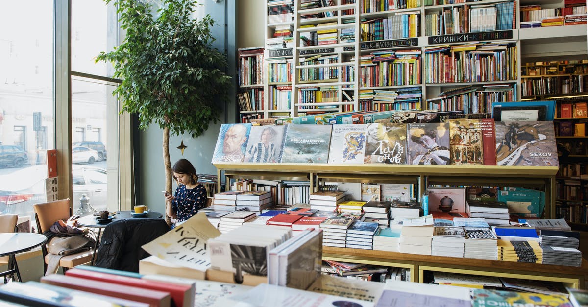 A single client to run games from different clients [closed] - Young female client in casual wear chatting on cellphone while sitting at table with cup of hot drink in cozy bookstore in afternoon