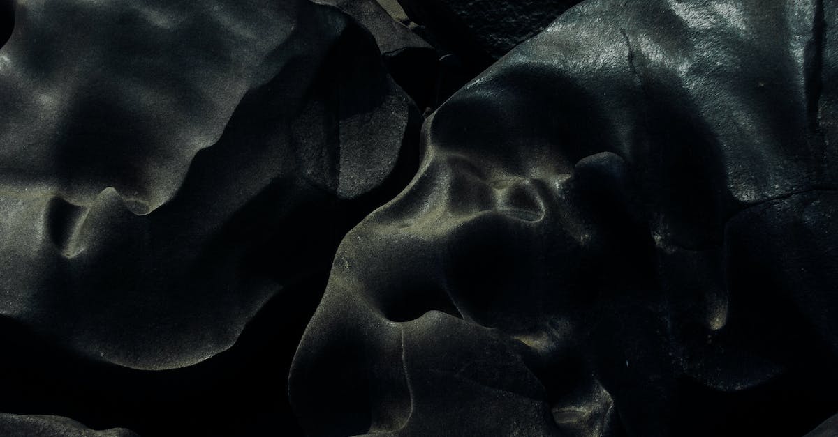 Accidentally dropped boulder in wrong hole in the distortion world - From above of abstract textured background of uneven wavy gray boulders on surface with holes and light spots