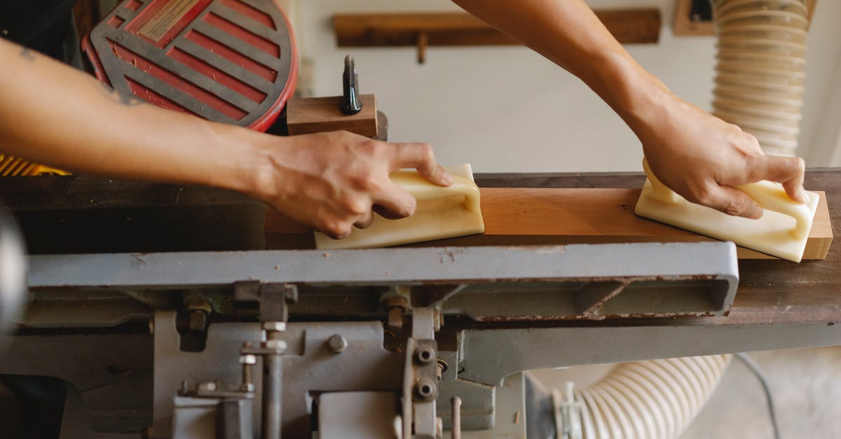 Allow players to automatically "Jump" from level X to level X+n - From above of crop anonymous woodworker leveling timber on professional equipment using manual instruments in workroom in daylight