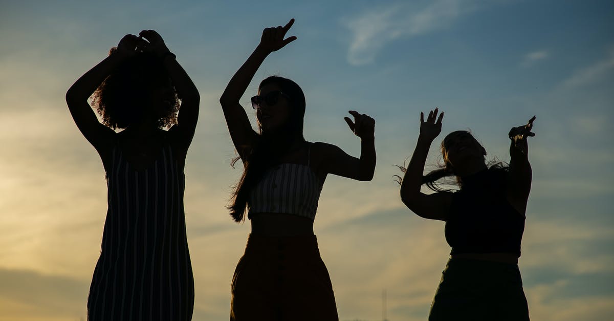 Any use to building up relationship with non party members? - Low angle silhouettes of unrecognizable young female friends dancing against cloudy sunset sky during open air party