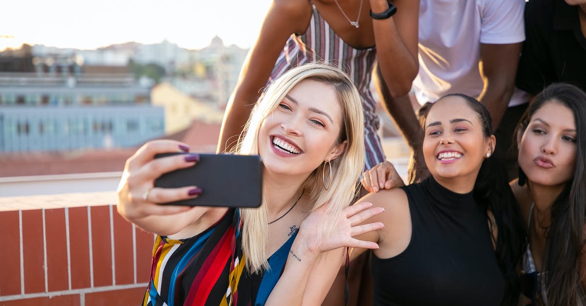 Any use to building up relationship with non party members? - Joyful young diverse millennials taking selfie during party in sunlight