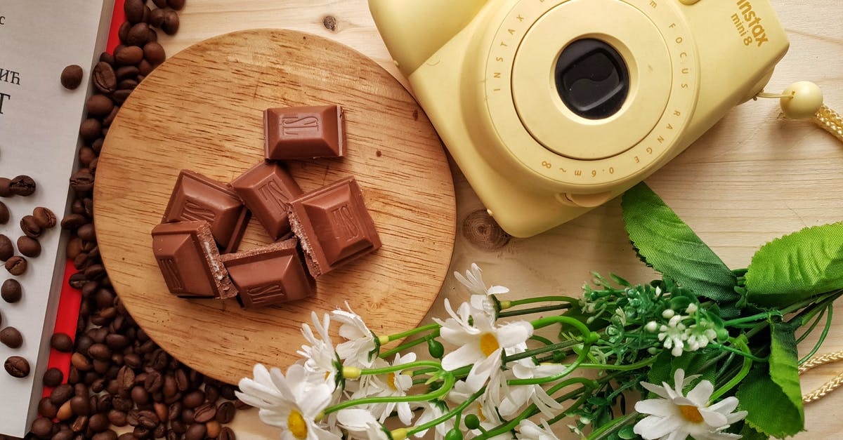 Are all agents identical except for their abilities? - Top view of delicious pieces of milk chocolate bar with filling on wooden board near heap of aromatic coffee beans and instant camera with artificial chamomiles on table