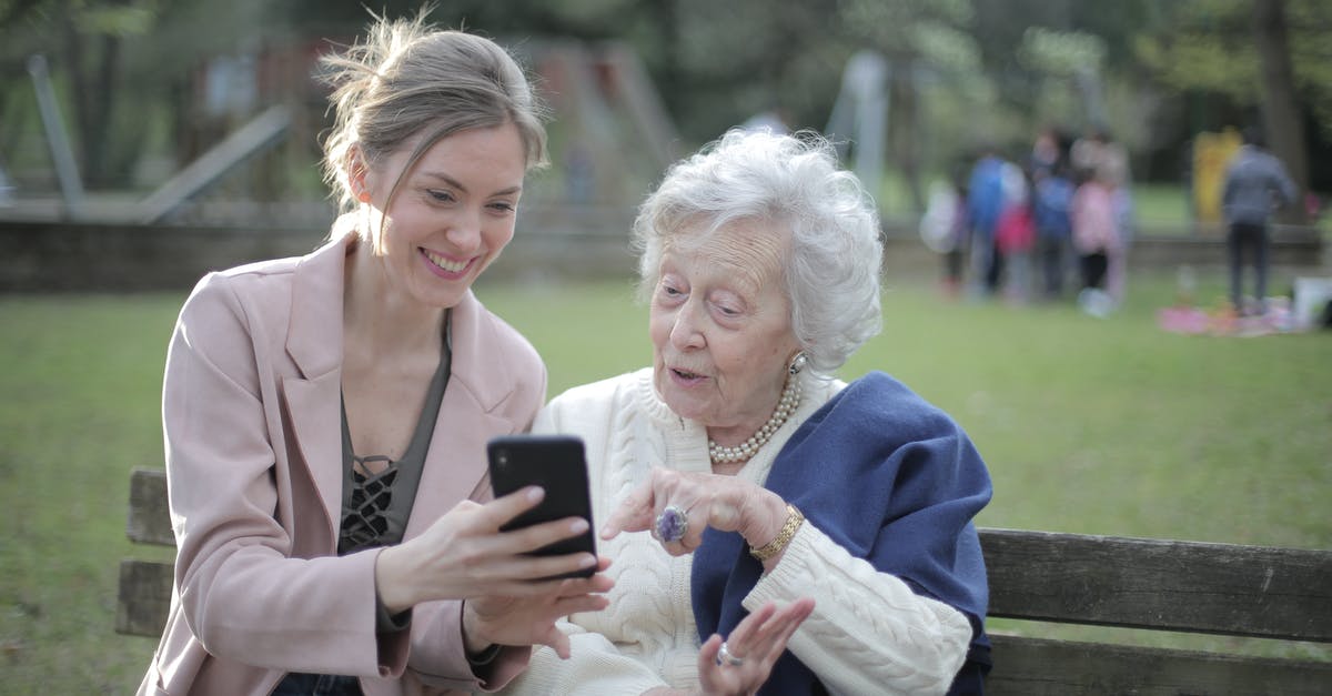 Are Ninten and Ness related in anyway in the Mother series? - Delighted female relatives sitting together on wooden bench in park and browsing mobile phone while learning using