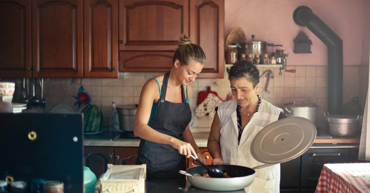 Are Ninten and Ness related in anyway in the Mother series? - Daughter and senior mother standing at table in kitchen and stirring dish in frying pan while preparing food for dinner