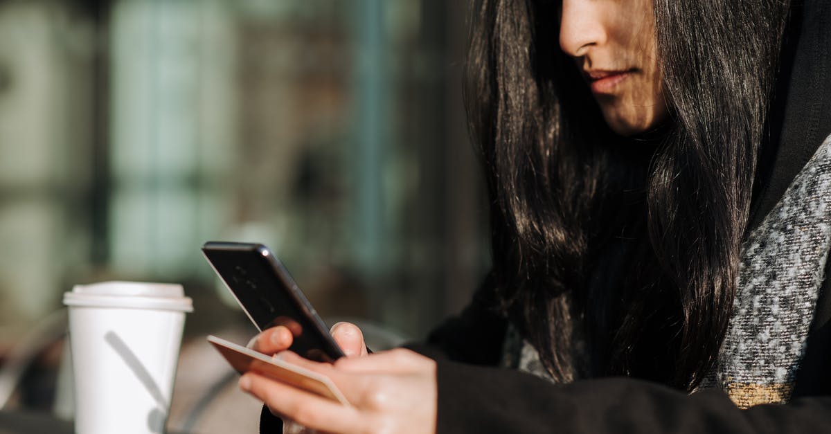 Are the cards a one-time use? - Crop ethnic shopper making purchase on smartphone with debit card