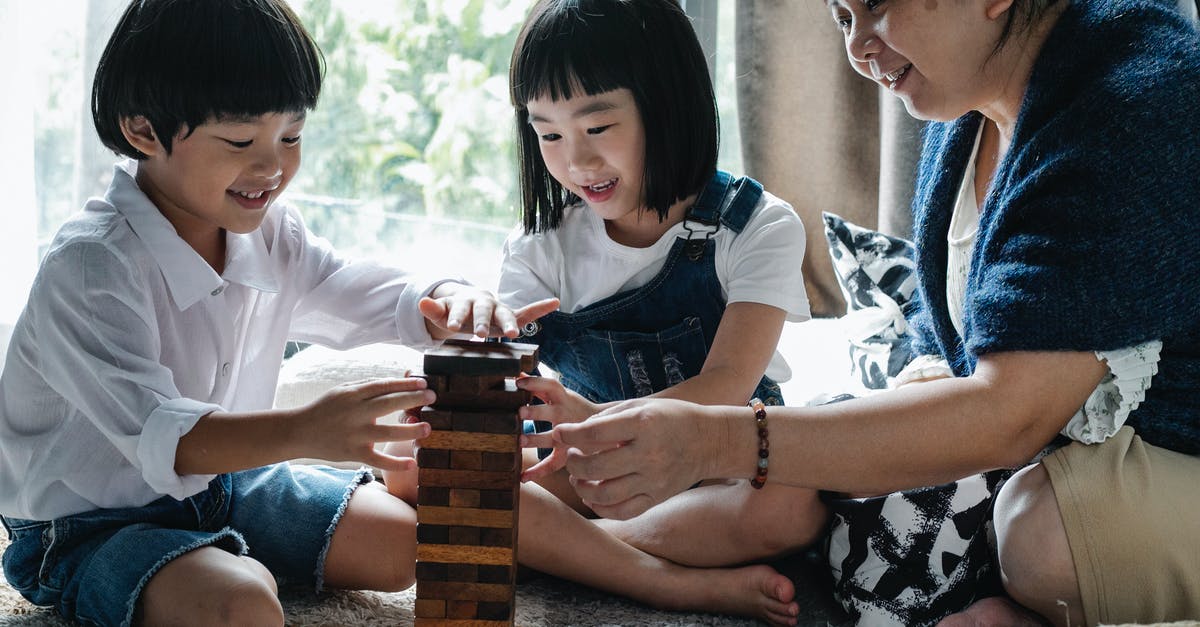 Are there any trade restrictions between the fourth generation Pokémon games? - Full body of happy ethnic little children with elderly grandmother sitting on floor and constructing wooden tower while playing board game at home