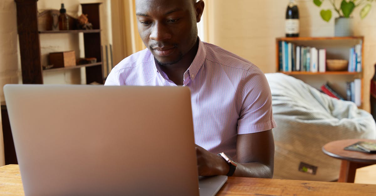 Are trading skills important for caravans - Concentrated African American male typing information on netbook at wooden table in cozy living room