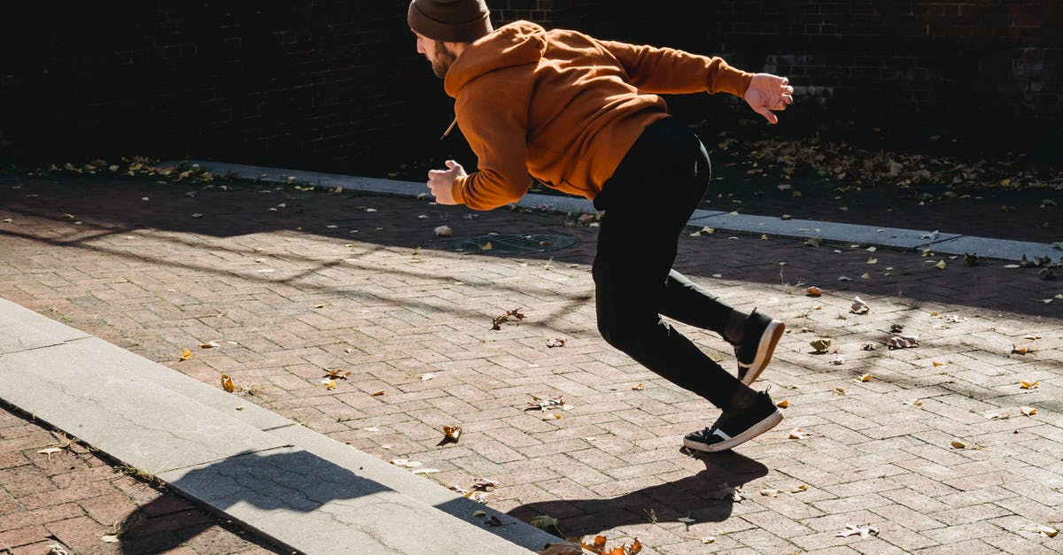 Autumn season challenge - Energetic faceless man running on pavement