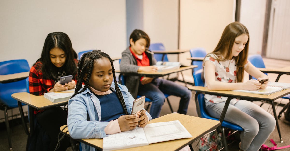 Berzerk Mondegreens or: What did he say? - Students Sitting Inside the Classroom While Using Their Smartphone