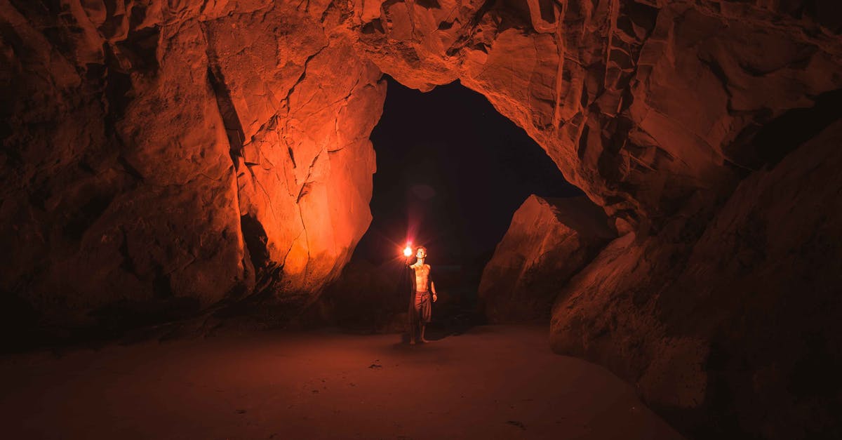 Best strategy to catch Snorlax on Pokemon Fire Red? - Person Standing and Holding Lamp Inside Cave