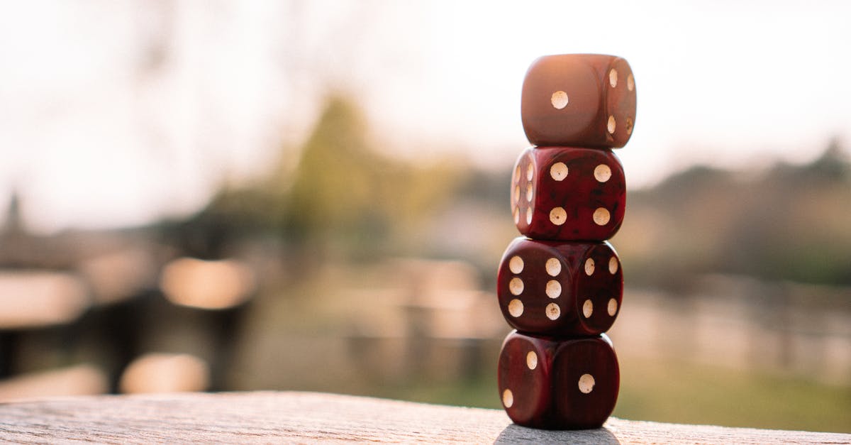 Breaking out of a neverending battle without leaving the match - Set of red dice stacked together on wooden table placed on sunny terrace in daylight