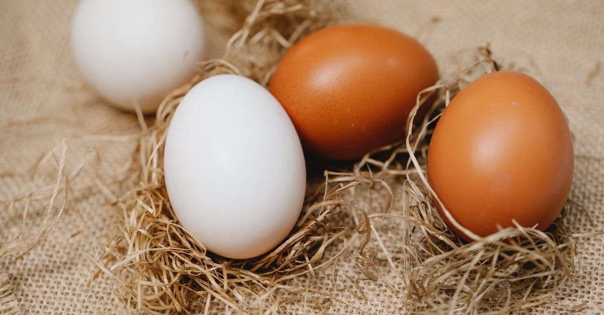 Brown Chickens and egg frequency - Chicken eggs among straw on table