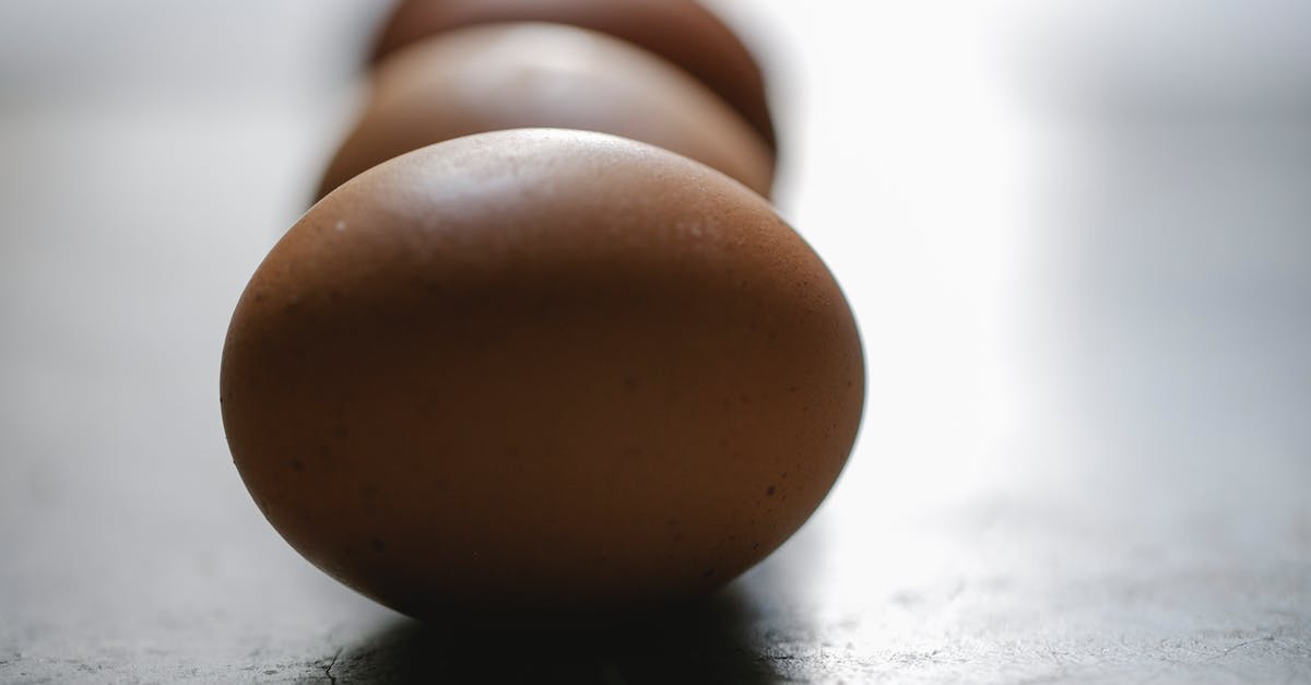 Brown Chickens and egg frequency - Row of brown chicken eggs placed on table in kitchen