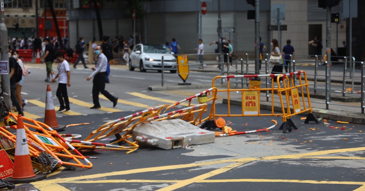 BTD5—Spike Factories—which upgrade path does the most damage to MOABs? - Crowd of people walking on sidewalk and pedestrian crossing on street with damaged fences after mass meetings