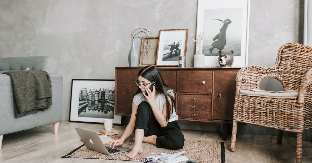 Call of Duty: Modern Warfare Remastered can't download - Focused young woman with laptop and smartphone in modern apartment