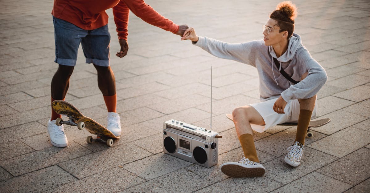 Can't hear any sound on True Skate - Young multiethnic male skaters giving fist bump and listening to music with boombox on street