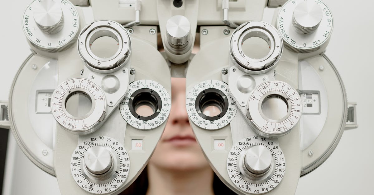 Can't inspect corpse in Kayran lair - Woman diagnosing vision on refractor testing device during eye examination in modern ophthalmology clinic