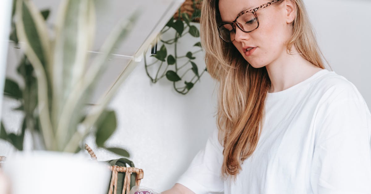 Can't make a map in Minecraft 0.14.2 - Low angle of focused female in eyeglasses and home t shirt standing at counter with green potted plants while cooking lunch snack at home