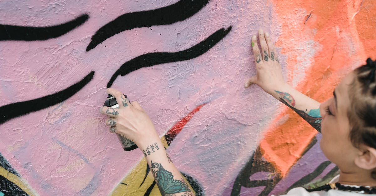 Can a city exploit tiles from two provinces? - Ethnic woman spraying paint on wall