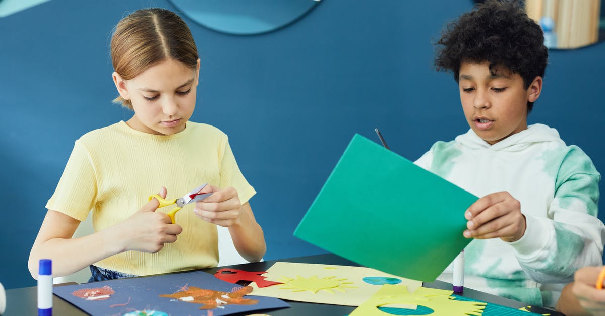 Can Crafting be Profitable? - Girl in White Crew Neck T-shirt Holding Blue Paper