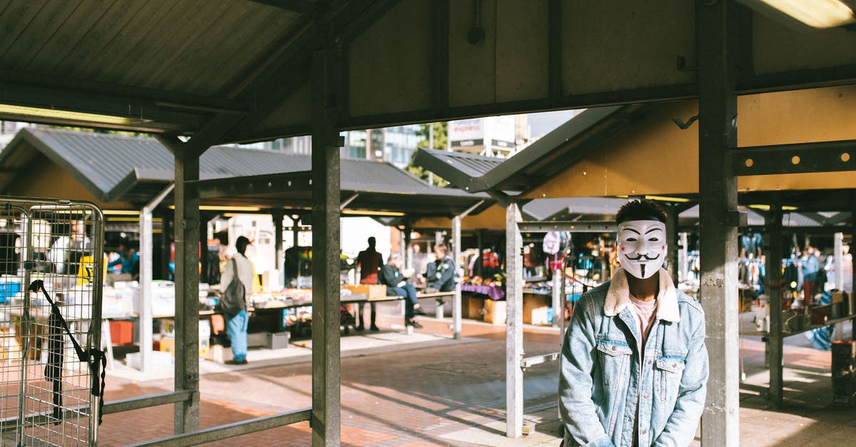 Can I change the appearance of my character? - Unrecognizable black man in stylish clothes and Anonymous mask standing in local market in city and looking at camera in sunny day