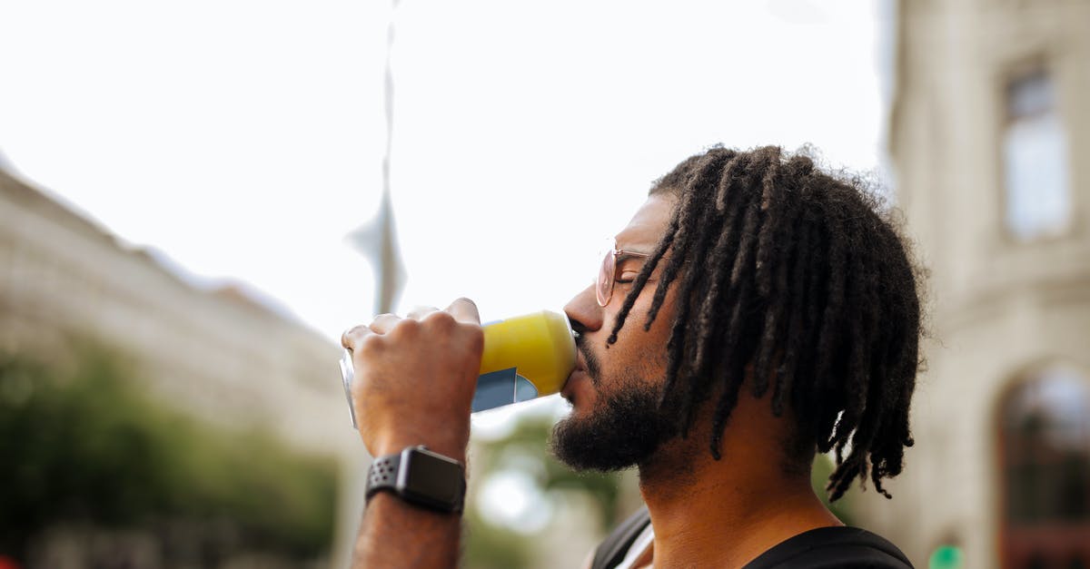 Can I change the appearance of my character? - Side view of adult Hispanic guy with dreadlocks in sunglasses and casual clothes with backpack and smart watch drinking yummy beverage from vivid yellow can while standing with eyes closed on street in downtown