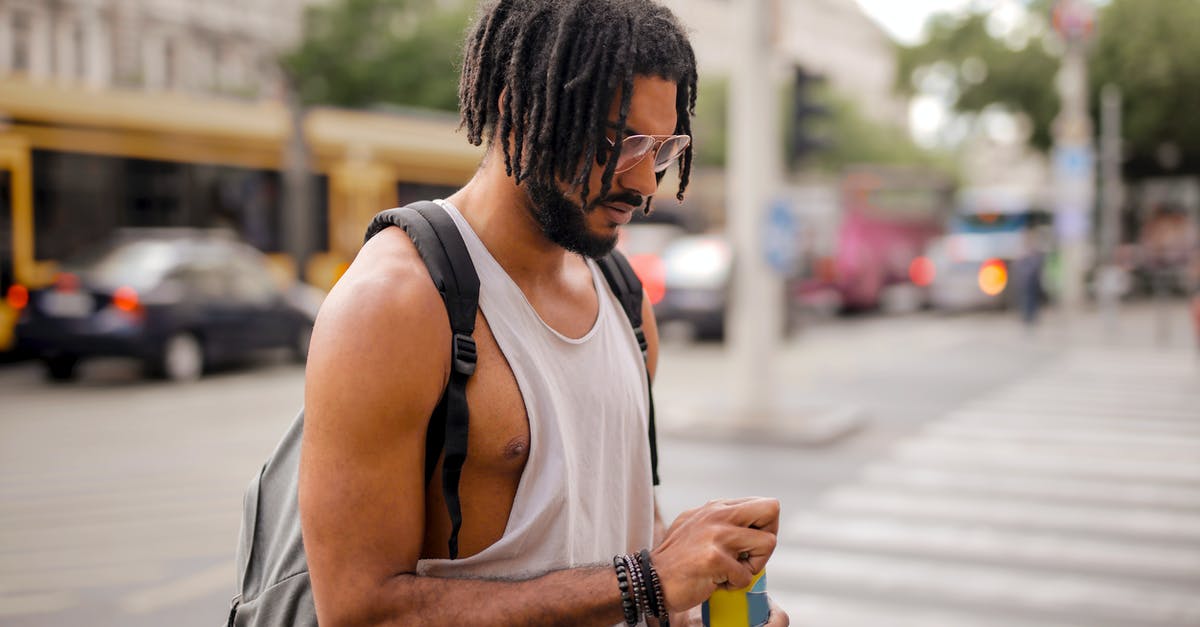 Can I change the appearance of my character? - Confident adult Hispanic male traveler in sunglasses and casual clothes with backpack opening can of drink while walking along pavement against blurred cars driving along street and empty crosswalk in downtown