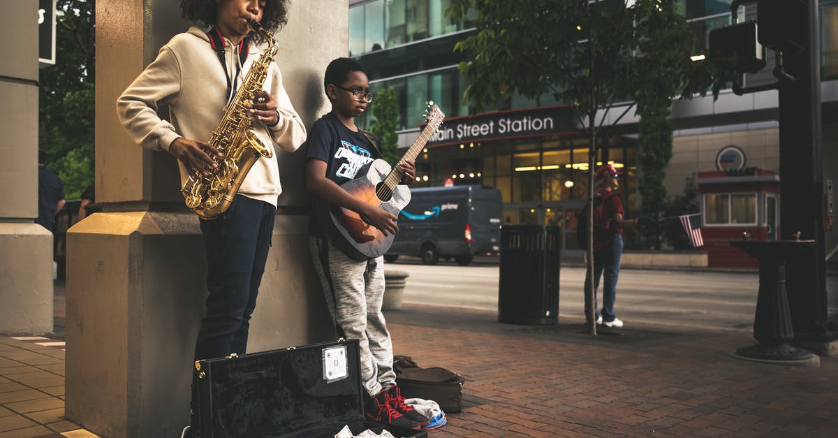 Can I earn achievements while playing custom songs? - Black children musician playing song on street