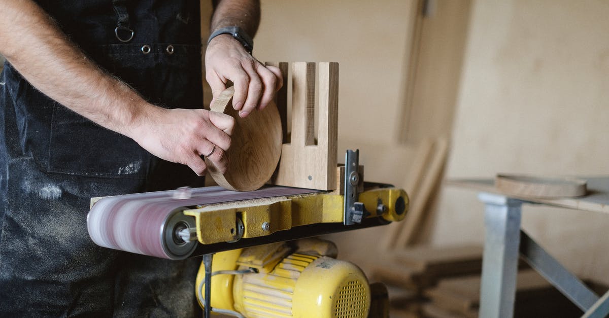 Can I find all the Tetra Master cards in Disc 4? - Anonymous male master using belt and disc sander to shape piece of wood  while working in professional carpentry with stack of wood