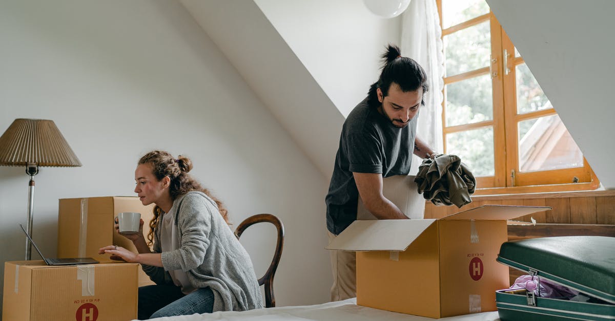 Can I move my new leaf save file to my computer? - Ethnic boyfriend unpacking box while woman using laptop at home