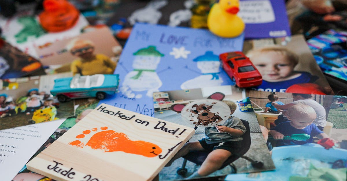 Can I play a downloaded game on a different account? - Various toys and colorful photographs of cute child on glass table at home