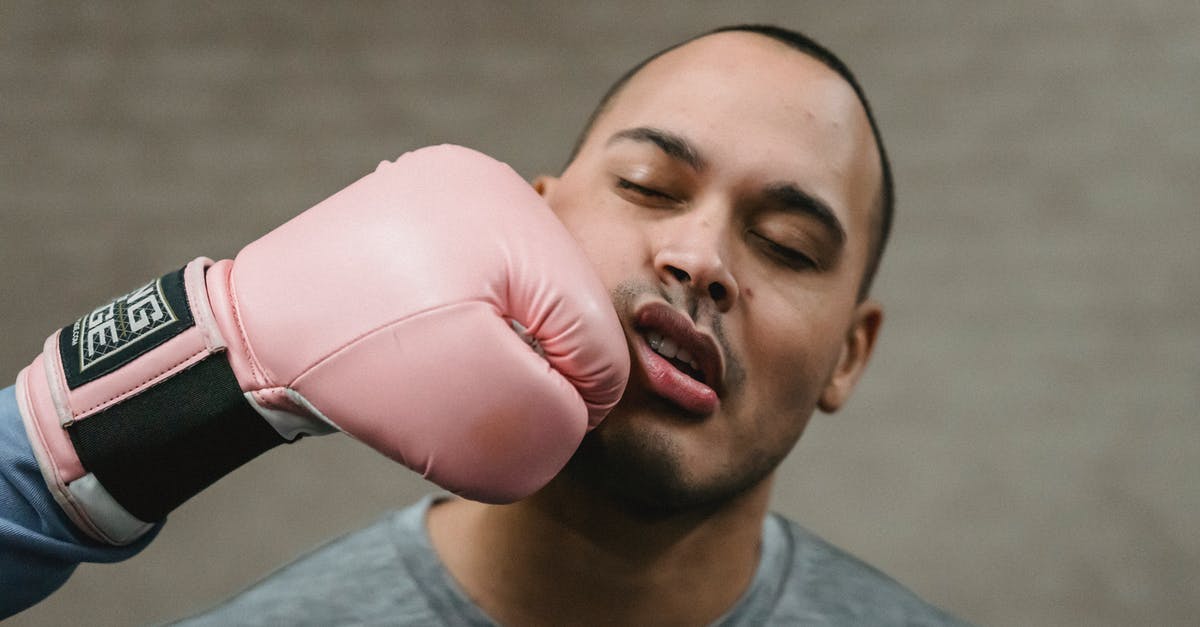 Can I refight Ring Fit Adventure's final boss? - Crop unrecognizable fighter in protective glove punching in face of young ethnic male opponent during boxing workout