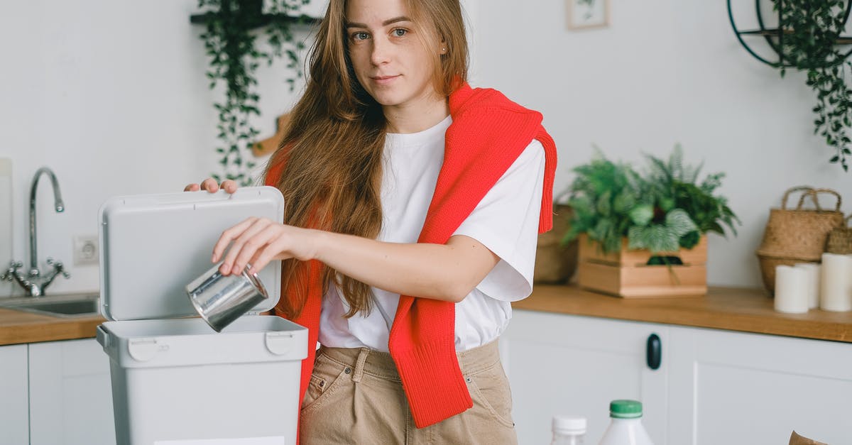 Can I save my highlights? - Responsible female sorting garbage while putting tin can into container for metal litter and looking at camera