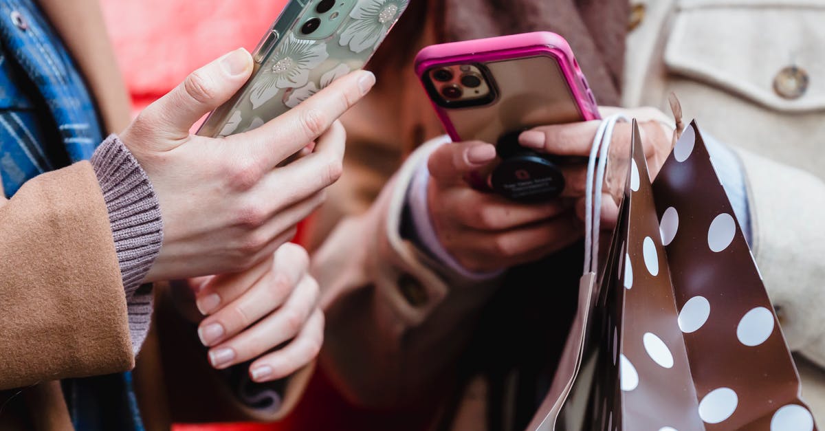 Can my friend play Street Fighter V online from shared library? - Unrecognizable ladies messaging smartphones on street