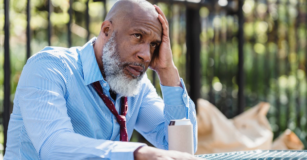 Can you break doors by throwing things at them? - Thoughtful African American man sitting at table with tin can