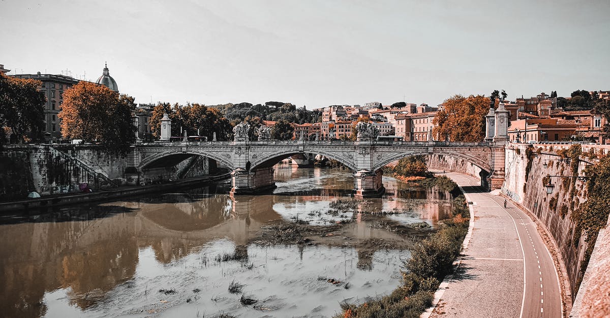 Can you Carve Fortifications into raised bridges? - Ancient arched bridge with carved columns over Tiber river flowing along embankment in old city Rome