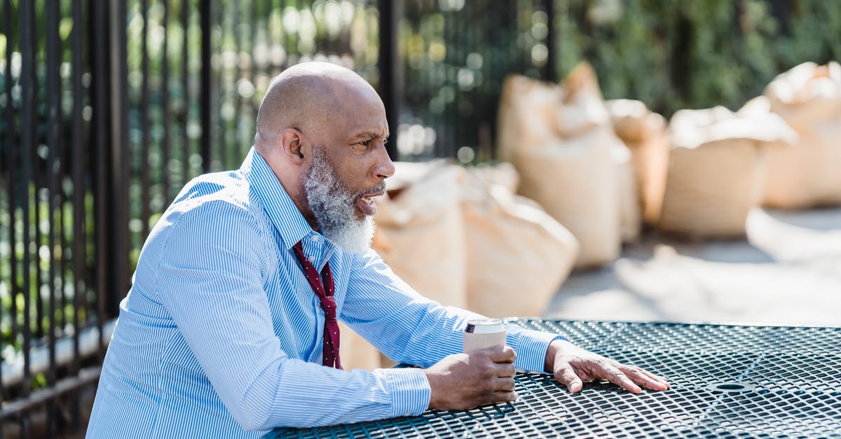 Can you re-recruit Dorn Il-Khan after dismissing him? - Side view of concerned African American male entrepreneur in formal clothes with can of alcohol beverage sitting at table on street