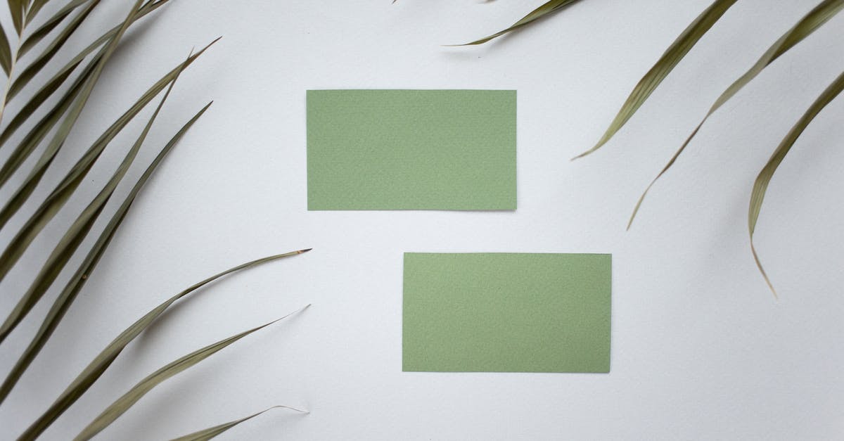 Can you trade Pokemon from Pokemon Emerald and Leaf Green with DS Lite? - Top view of green mock up business cards placed on white background near plant with lush leaves in modern studio