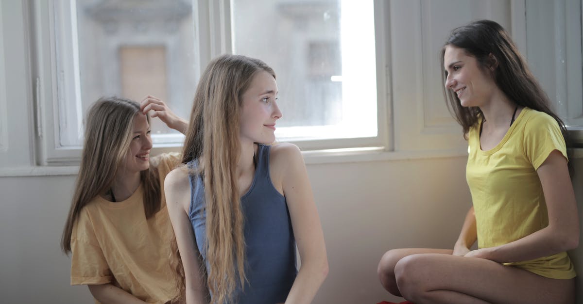 Can’t talk to my teammates - Group of young friendly women in panties and t shirts gathering on floor in messy room and chatting while smiling and looking at each other