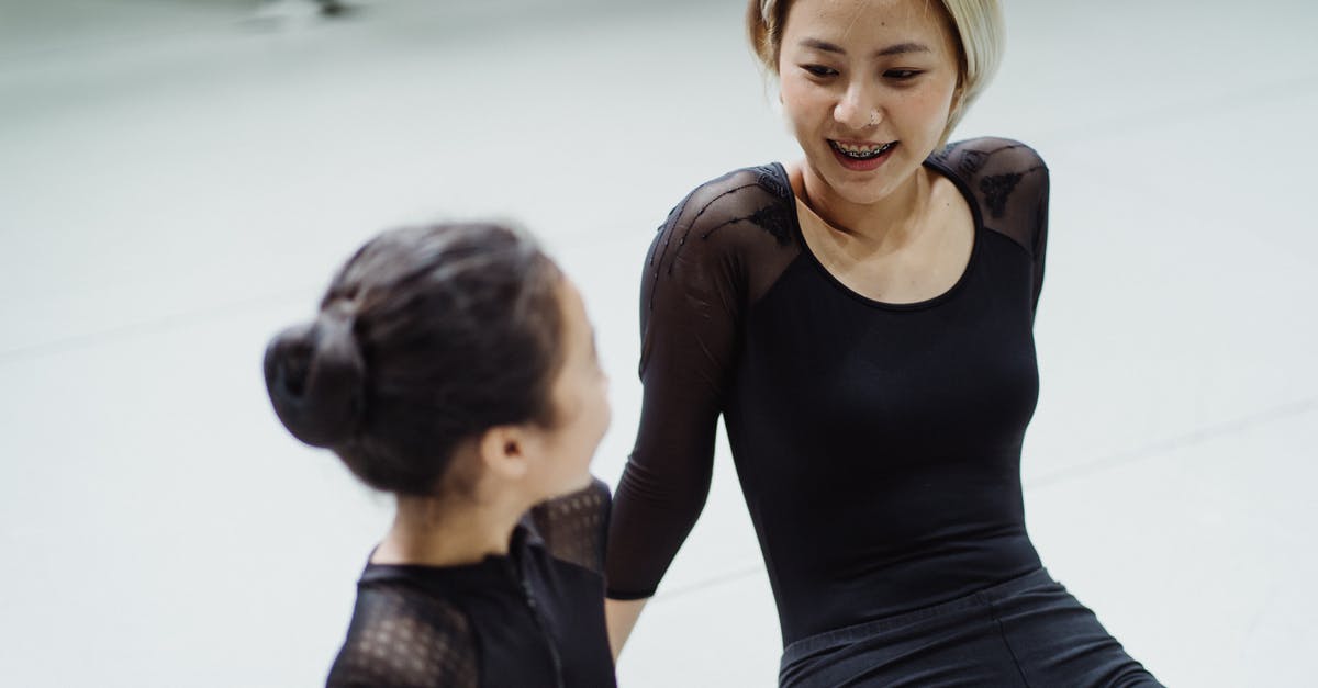 Change or swap fit skills damage with others - Content fit female ballet dancer and girl in leotards sitting on floor in ballet school and discussing movement techniques