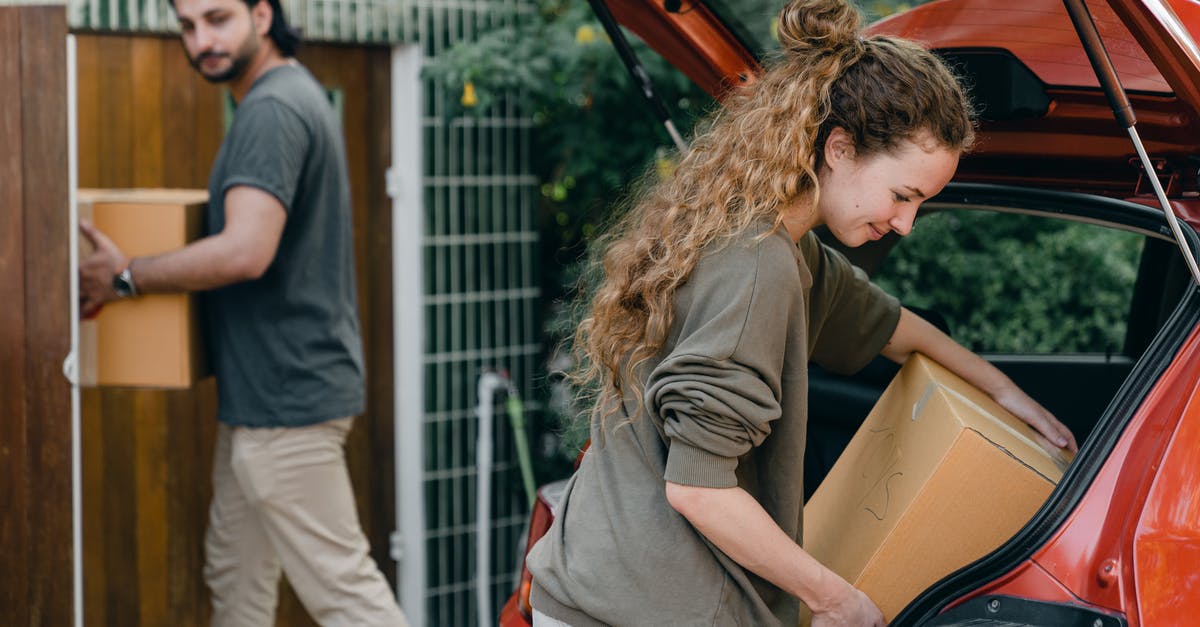 Changing NNID on Mario Edition New 3Ds - Multiethnic young couple in casual wear taking carton boxes out of automobile trunk near newly bought house on summer day