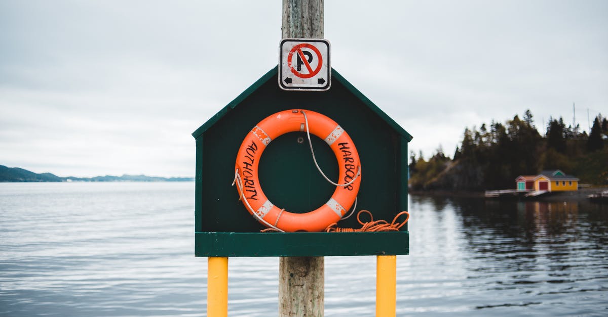 Cloud save issues - Colorful stand with red lifebuoy located on quay near peaceful rippling pond in countryside on cloudy day