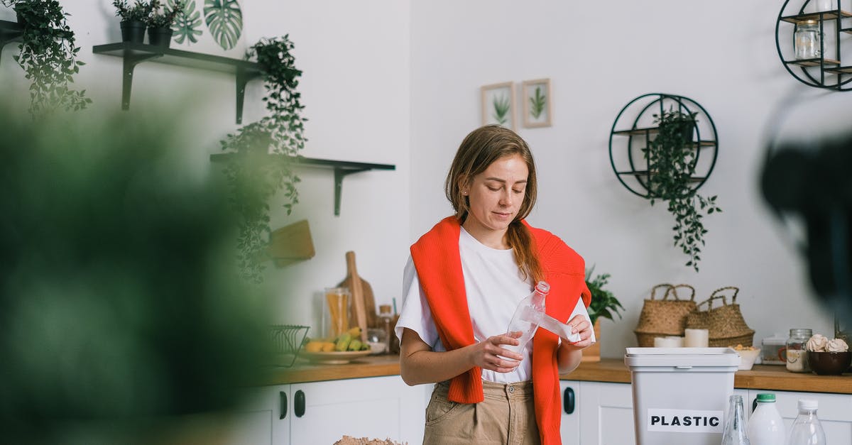 Counter strike 1.6 / condition zero - spawn immediately after death - Calm woman in casual clothes standing near table and cleaning plastic bottle while sorting rubbish in light kitchen in daytime