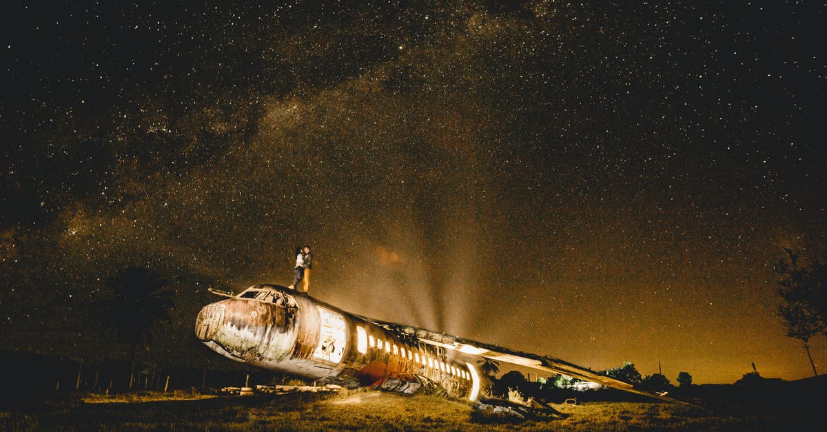 Crashed when storing Pokémon - Anonymous couple of travelers embracing on abandoned plane at dusk