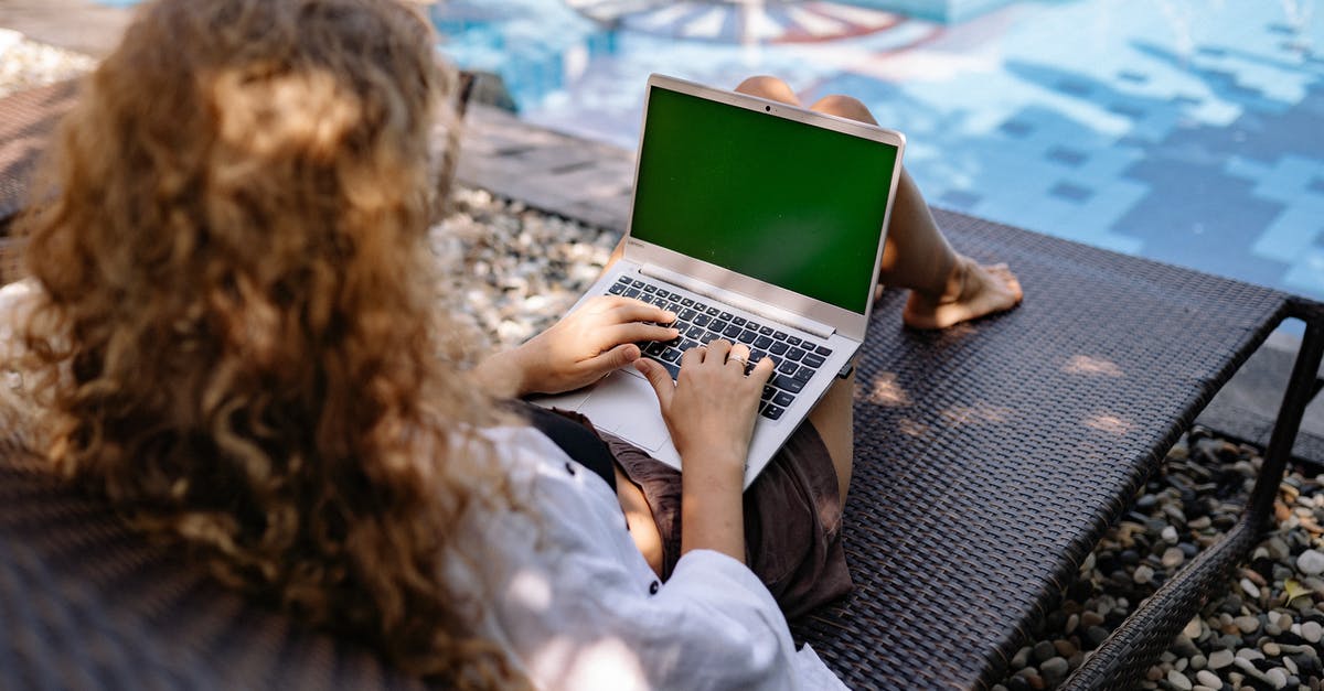 Dead pool fatality doesn't work in Mortal Kombat 2 - From above back view of anonymous female freelancer typing on portable computer while lying on sunbed near swimming pool with transparent water in sunlight