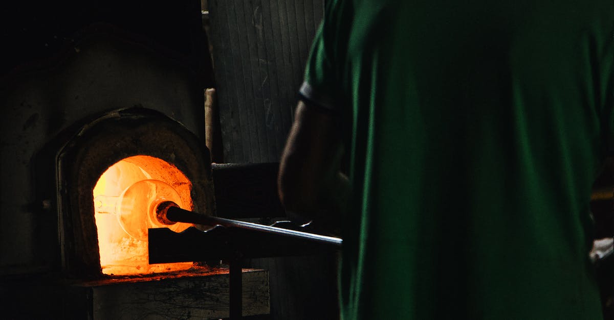 Deadlock: Items needed to upgrade furnace need upgraded furnace to be crafted - Back view of crop unrecognizable professional worker standing in front of furnace while blowing glass in workshop