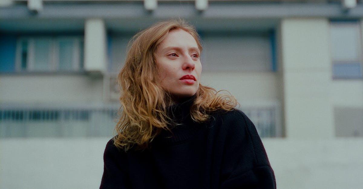 Deino before the E4 - Redhead Woman with Long Wavy Hair Standing Before Residential Building