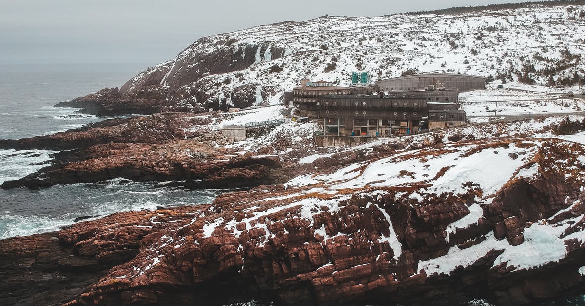 Destroying certain blocks within the range of an entity - Drone view of mountain range with forgotten buildings on cliffs covered with snow in overcast