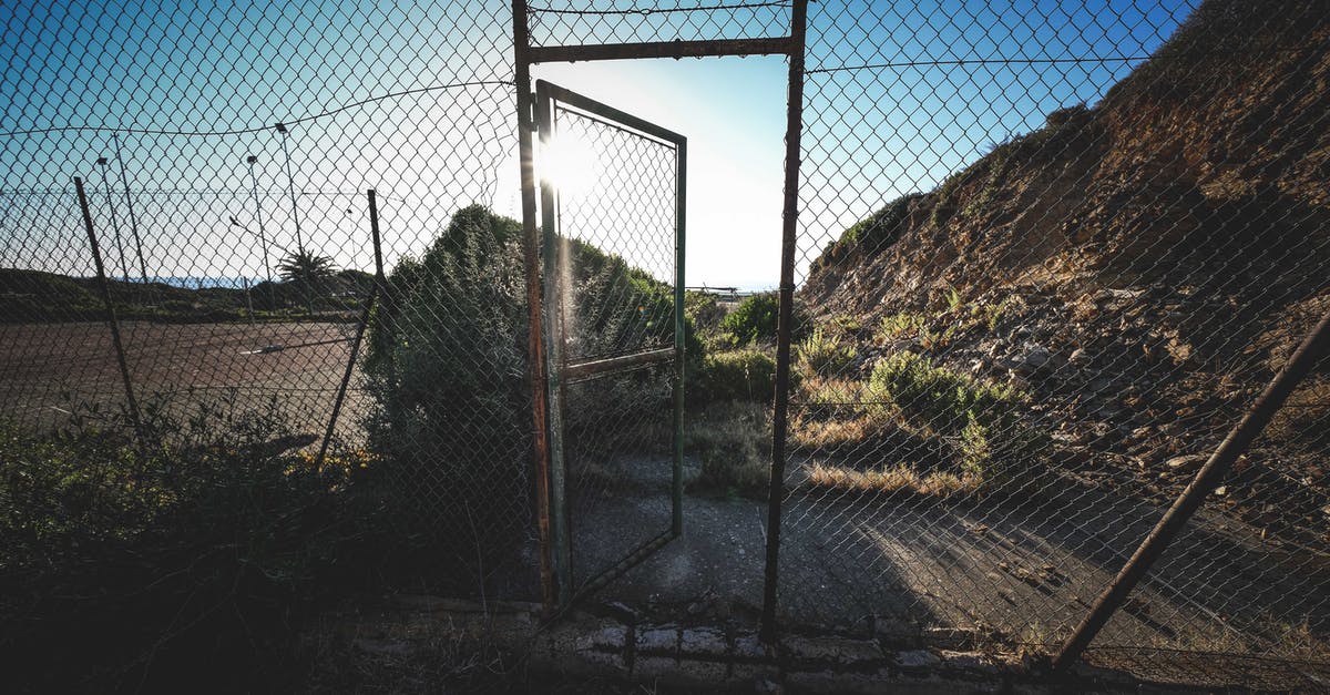 Destroying certain blocks within the range of an entity - Old rusty chain link fence near rough mountain against cloudless blue sky on sunny day