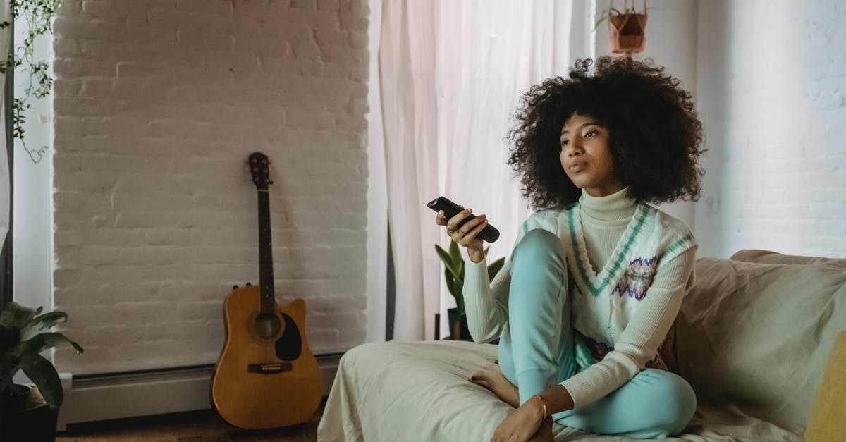 Disabling switch online rewind function - Young black lady resting on sofa and watching TV at home